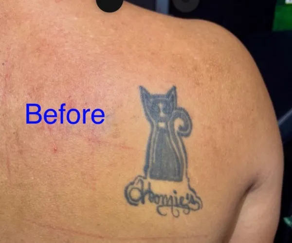 Before the cover-up on the shoulder blade: A solid black cat silhouette and a faded script name.