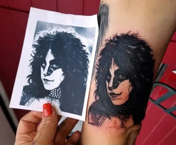 Portrait, shown with its reference — Black & gray realism tattoo on inner upper arm