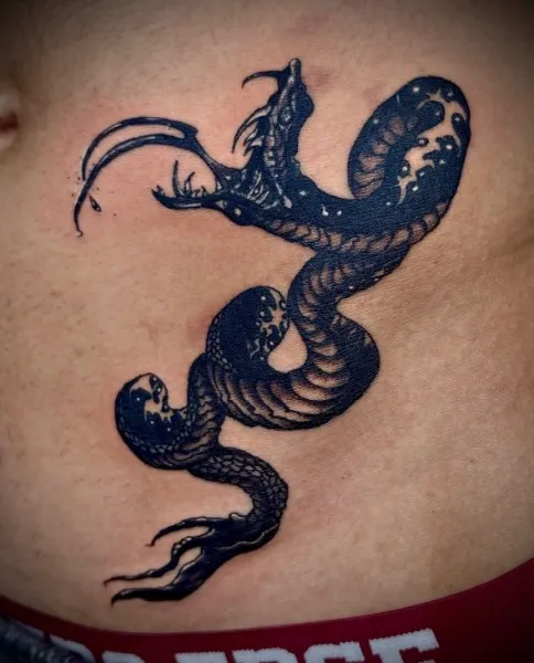 Starry dragon-serpent — Illustrative blackwork tattoo on stomach / hip